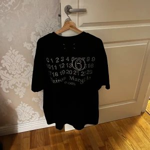 Maison margiela T-shirt - Helt ny Maison margiela t shirt med tryck på ryggen, lappen hänger kvar och tröjan är helt oanvänd, köpt på vinted av en säker säljare, tyvärr inget kvitto men tröjan är äkta