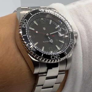 NH35 AK Submod - Helt sprillans ny. Klockan ar byggd för hand av oss, endast uttagen for fotografering. Utrustad med ett automatiskt NH35 urverk fran Seiko och safirglas. Verktyg till lankarna medföljer! Logotyp: Uppsala Stadsvapen med initialerna AK.