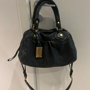 Marc Jacobs väska  - Marc Jacobs väska i mini modellen som är gjort av äkta läder vilket gör att väskan skada sig inte av regn eller snön, perfekt nu inför vintern😍 Jätte fin verkligen. Skriv om ni har några frågor🫶🏻 Kan även möta upp i centrala Stockholm📍