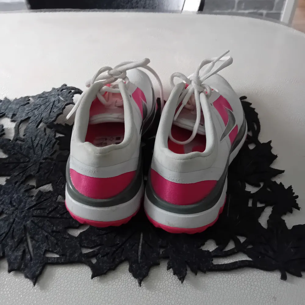 Säljer ett par vita och rosa Nike sneakers i bra skick. De har en snygg design med rosa detaljer och den klassiska Nike-loggan på sidan. Skorna har snörning och är perfekta för både vardag och träning. Storlek dam 40. Passa på att fynda dessa stiliga och bekväma skor!. Skor.