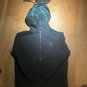 Ralph lauren zip - En snygg Ralph lauren tröja med ett coolt mönster i luvan. Har ett väldigt litet hål i armen som syns på sista bilden. Det står 14/16 år men passar snarare någon som är runt 12 år eller runt 150 cm