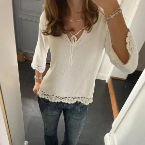 Vit stickad tröja  - Vit stickad tröja med snörning från Ellos i storlek 34/36. Skulle säga att den passar S och M. Fint skick. Använd gärna köp nu!