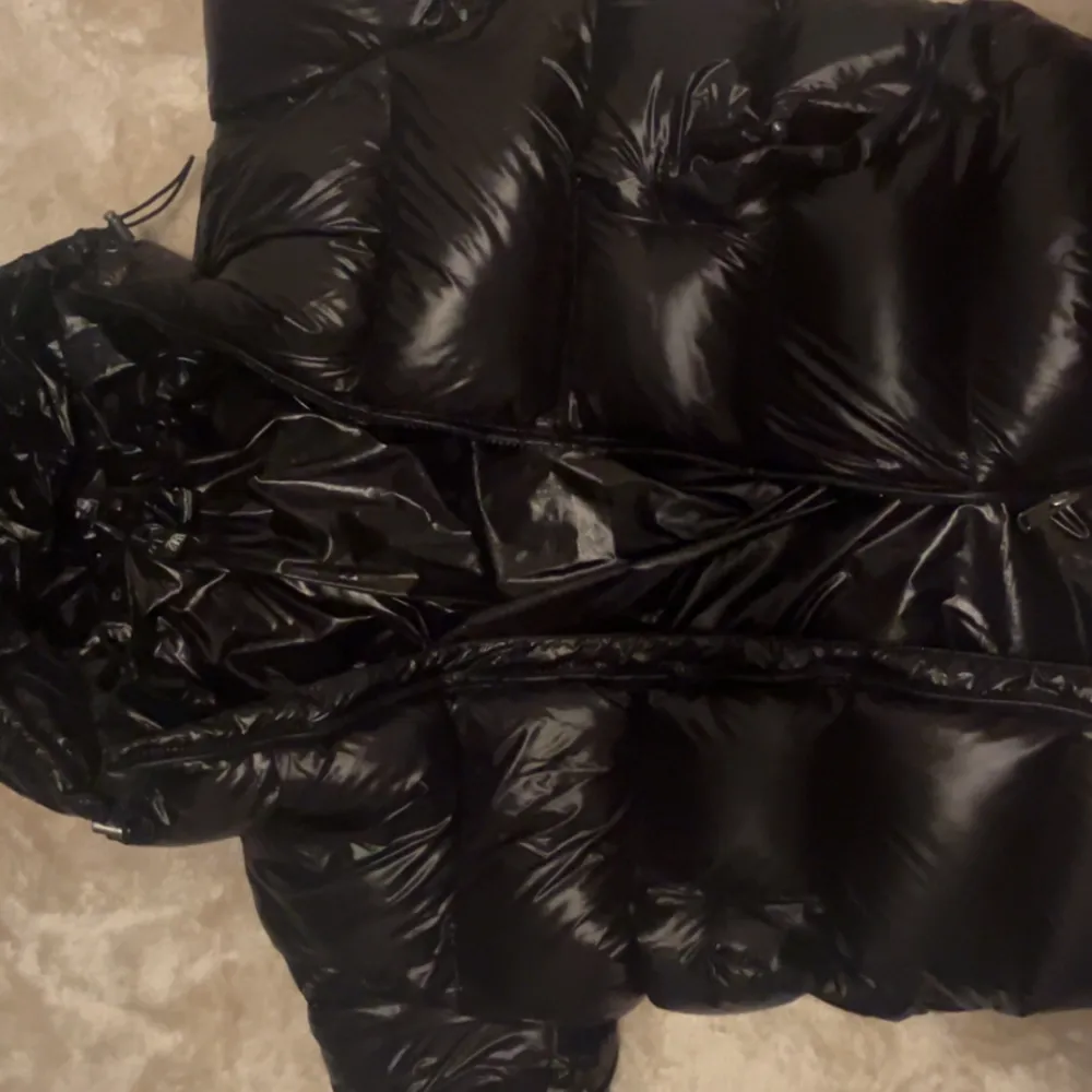 Säljer en svart pufferjacka från Zara. Jackan har en glansig finish och är utrustad med en dragkedja framtill. Perfekt för kyliga dagar med sin vadderade design och huva.HAR ANVÄNT DEN 2 GÅNGER.Priset kan diskuteras.storlek M.Köpte för 1,400. Takit.