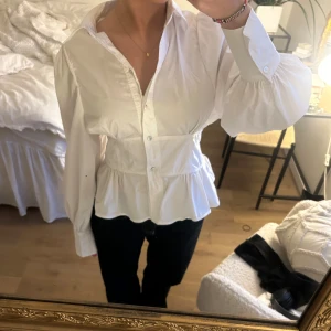 Vit blus/skjorta  - Snygg vit blus med knappar och volangdetaljer i midjan. Använd enstaka gång så därav i fint skick.💕storlek 38 men passar på mig som vanligtvis har 34-36