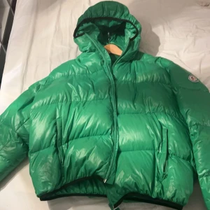 Moncler OG pufferjacket gräs grön - Nu säljer jag då min fina antika moncler för behöver pengar till flytt, allt är i bra skick förutom en lapp som sityer på insidan som låsnat lite i hörnet men 3-4 styngd med nål och tråd så är den som ny igen, antik är den för den är en OG pufferjacket från moncler i slutet av 19 talet till 2002 talet, den är äkta som alla samlare vet och vi som kan mer om jackor vet att nästan alla äldre märkesjackor har ingen QR kod, kvittot finns inte. Mer info skriv bara ett sms