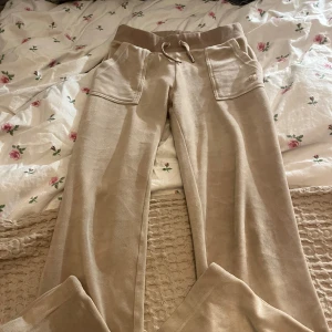 Juicy couture byxor  - Säljer ett par bekväma beige juicy couture byxor i storlek xs, snörning i midjan och praktiska fickor framtill. Perfekta för en avslappnad stil.