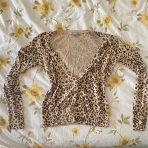 Leopardmönstrad kofta från H&M - Säljer en leopardmönstrad kofta från H&M i storlek XS. Koftan är tillverkad av 50% bomull och 50% modal, vilket gör den mjuk och bekväm. Perfekt för att lägga till lite mönster i din garderob!