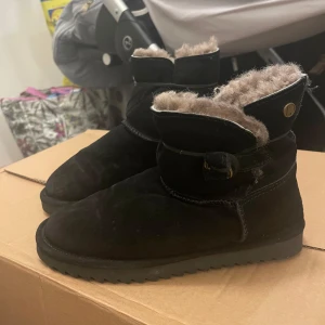 Svarta boots från Axelda - Säljer ett par svarta boots från Axelda med mjukt foder och en bekväm passform. Skorna har en överdel i skinn och tyg, samt en syntetisk sula. Perfekta för kyligare dagar. Storlek 38 