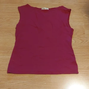 Vintage Vinröd topp  - Min mammas gamla tröja från      90 -talet 💞   står large på tröjan men sitter mer som M!!                          inga defekter  💞                                             Säljer en vinröd ärmlös topp från Pipeline. Perfekt för varma dagar eller som ett lager under en jacka. Toppen har en enkel design som gör den lätt att matcha med olika outfits.