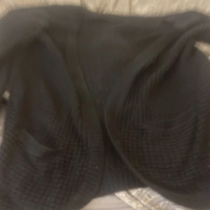 Svart stickad kofta från ONLY - Säljer en svart stickad kofta från ONLY. Den har en mysig och ribbad textur som passar perfekt för kyligare dagar. Koftan är i storlek M och har en klassisk design som är lätt att matcha med olika outfits.