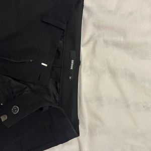 Svarta byxor från Bik Bok - Snygga svarta byxor från Bik Bok med en stilren design. De har en dragkedja och knapp framtill för enkel stängning. Perfekta för en chic och elegant look. De virala från TikTok! 