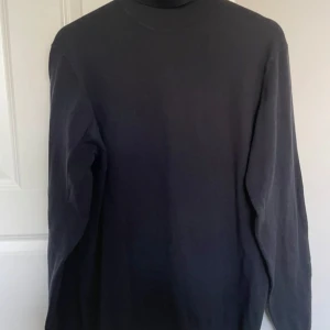 Svart långärmad polo - Säljer en stilren svart långärmad polo. Perfekt för kyligare dagar och enkel att matcha med olika outfits.