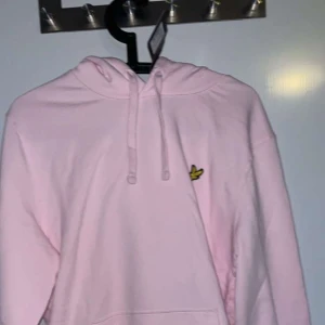 Rosa hoodie från Lyle & Scott - Säljer en snygg rosa hoodie från Lyle & Scott med deras ikoniska logga på bröstet. Tröjan har en klassisk huva med dragsko och långa ärmar. Perfekt för en avslappnad stil. 🩷