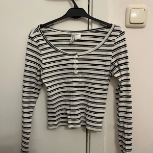 Randig ribbad topp från H&M - Randig ribbad topp från H&M i svart och vit. Använd några gånger men i jättefint skick, strl S, passar även mig som XS.