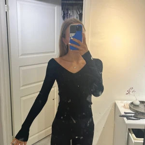 Svart långärmad topp - Snygg svart långärmad topp med v-ringning. Perfekt för en stilren look och passar till många olika outfits.