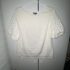 Vit blus från Stockh LM - Säljer en elegant vit blus liknande Tröja från Stockh LM med ett diskret mönster. Blusen har korta ärmar och en rund halsringning. Perfekt för lite finare sammanhang men funkar också bra mer vardagligt, hoppas du gillar 🥂