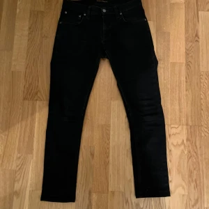 Svarta jeans från Nudie Jeans - Snygga svarta jeans från Nudie Jeans med en klassisk femficksdesign. De har en slim passform och är tillverkade i ett slitstarkt material. Perfekta för en stilren look. De har storleken W29 L32 men passar mindre.Skriv för fler frågor eller funderingar 🙏😁
