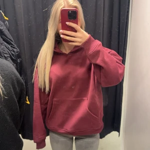Vinröd hoodie - Säljer en mysig vinröd hoodie med stor ficka framtill och långa ärmar. Perfekt för kyliga dagar. Aldrig använd enbart testad