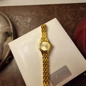 Guldfärgad klocka - Elegant guldfärgad klocka  med en klassisk rund urtavla och stilrent armband. 