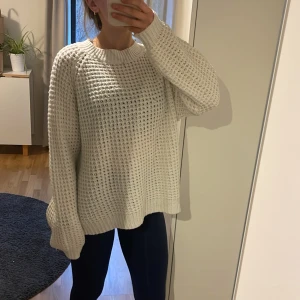Vit stickad tröja - Mysig vit stickad tröja med lång ärm och rund halsringning. Har några mindre noppror men är i fint skick! I strl M men passar mig som är XS om man vill ha den lite längre.