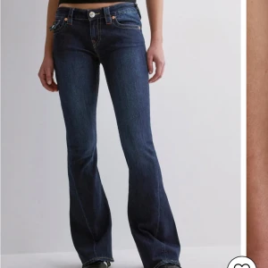 Mörkblå True Religon Jeans - Snygga mörkblå jeans från True Religion med låg midja och flare-stil. Byxorna är köpta på Nelly och är i användt men gott skick! 