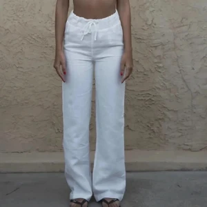 Vita linnebyxor med snörning - Jättesnygga linnebyxor från Alice Stenlöfs märke A-dsgn. Byxorna är helt oanvända då de varit för stora och långa på mig. Dock jätteskönt material så önskar jag kunde ha de själv!! (Har likadana oanvända i beige också om någon skulle vara intresserad). Nypris ca 800 kr🩷🩷