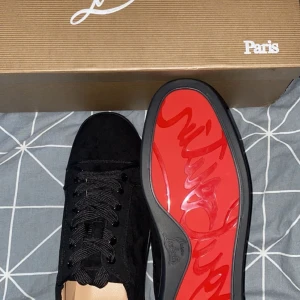  Christian Louboutin skor - Snygga svarta sneakers från Christian Louboutin med den ikoniska röda sulan. Skorna har snörning och är tillverkade i mocka 