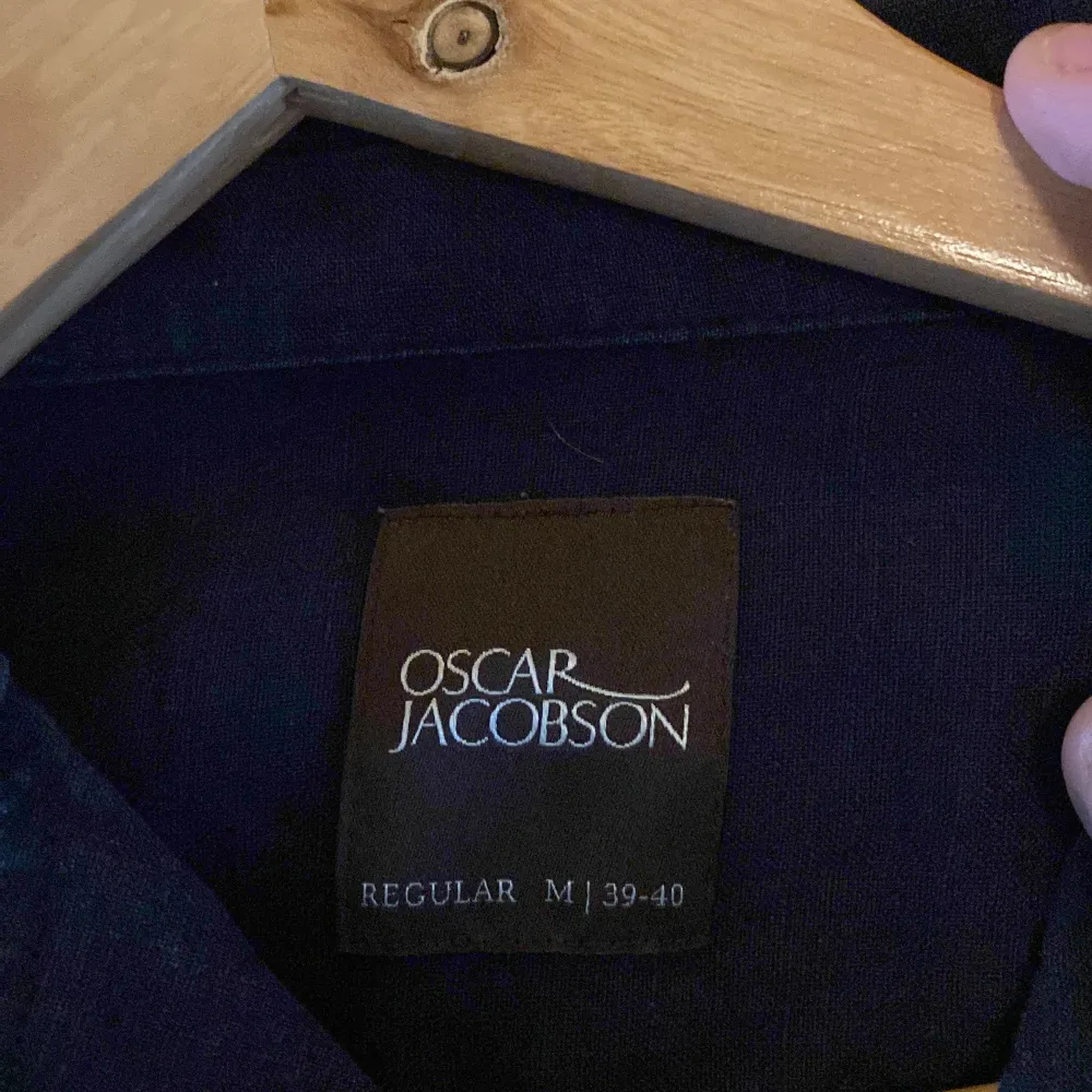 Snygg mörkblå skjorta från Oscar Jacobson i storlek M. Skjortan har långa ärmar och en klassisk krage med knappar framtill. Perfekt för en stilren look. Original pris 1500kr. Paidat.
