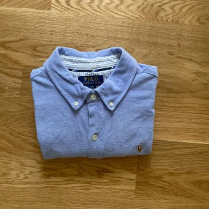 Ralph lauren skjorta - Hej!Jag säljer en ljusblå Ralph lauren skjorta i superbra skick, inga defekter! Den är storlek 14-16 som passar XS-S! Jag är 170 och den sitter bra på mig, passar folk runt 160-170 skulle jag tro. Be gärna om fler bilder och ställ frågor. Mvh Carl!