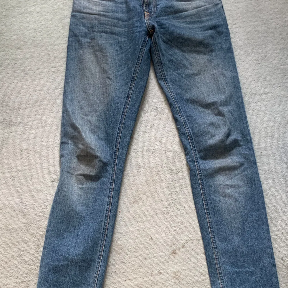 Säljer ett par snygga blå jeans från Nudie Jeans. De är i bra skick och är strl W26 men passar även 27. de är i en Lopes fit modell och säljes för 200kr. Jeans & Byxor.