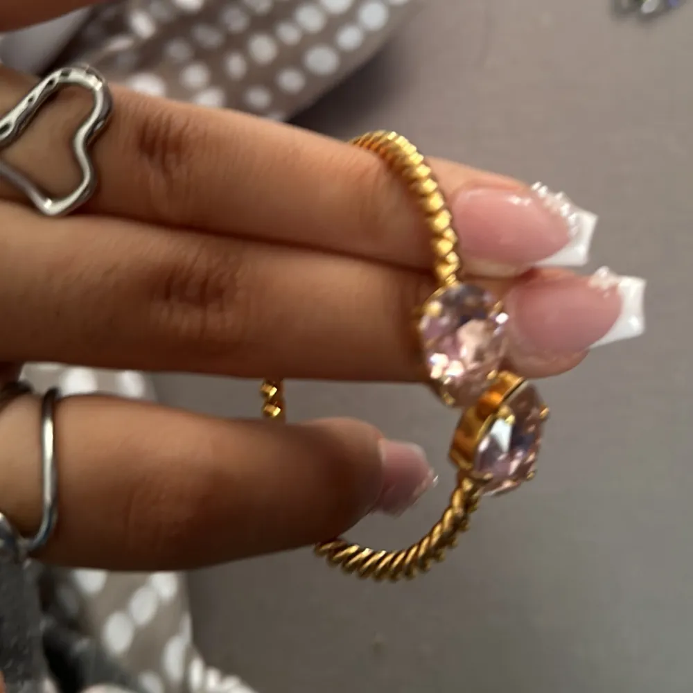 Sjukt fint armband från Caroline svedbom i guld med rosa stenar använd få tal gånger med tanke på att jag inte använder guld smycken . Accessoarer.