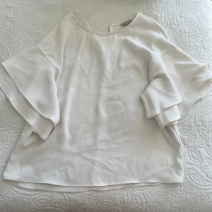 Vit blus  - Säljer denna blusen då den inte används längre, liten fläck men går att ta bort 