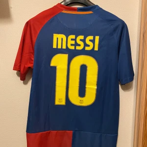 Barcelona 08/09 Champions Leauge - Roma - Säljer en ikonisk blå och röd fotbollströja från Nike med Messi och nummer 10 på ryggen.