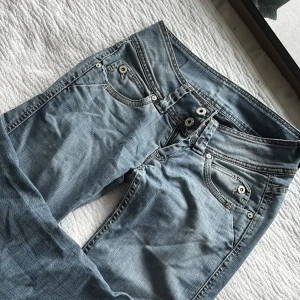 Ljusblå jeans med raka ben - Snygga ljusblå jeans med raka ben och klassisk femficksdesign. De har dubbla knappar och dragkedja i gylfen samt dekorativa sömmar på bakfickorna. Perfekta för en avslappnad stil.