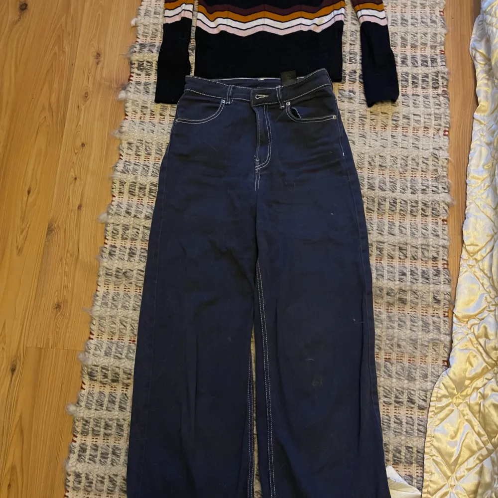 Snygga mörkblå byxor från H&M med vita sömmar. Perfekta för en stilren look. Byxorna har en klassisk design med normal passform och är tillverkade i ett bekvämt material.. Farkut & Housut.