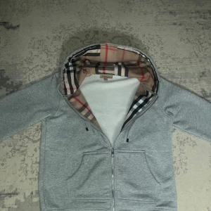 Burberry Zipper - Grå Burberry Zipper. I väldigt gott skick. Säljer för att den inte passade. Passar för M-S