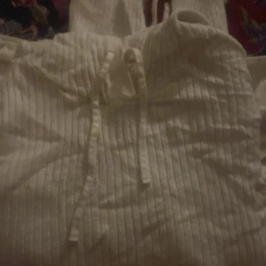 Vit ribbad hoodie - Säljer en vit ribbad hoodie med knytband i midjan. Perfekt för en avslappnad stil. Den har en bekväm passform och en mysig huva.