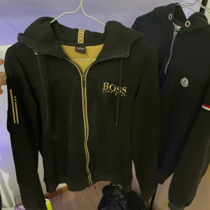 Hugo Boss zip - Nypris ca 2000kr, har ett litet hål på ena armbågen som syns på sista bilden,  rätt bra skick, mer bilder privat.