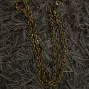 Guldfärgat tvinnat halsband - Snyggt guldfärgat halsband med tvinnad design. Perfekt för att ge en elegant touch till din outfit. Halsbandet har en praktisk låsning som gör det enkelt att ta på och av.
