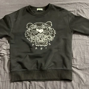 Kenzo tröja - Säljer en svart tröja från Kenzo då den inte passar mig längre. Tröjan är köpt för 2500 från Vestiaire Collective. Tröjan är i storlek S, Priset är inte hugget i sten så kom med förslag. Kan ta byten beror på vad men helst pengar.