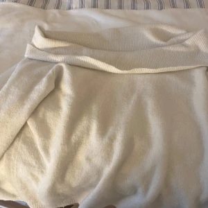 Vit stickad off shoulder tröja - Säljer en vit stickad off shoulder tröja från märket Cubus. Tröjan har en ribbad krage och är tillverkad i en blandning av polyester, polyamid, ull och mohair. Perfekt för kyligare dagar med sin mjuka och varma känsla. Passar bra till både jeans och kjol.