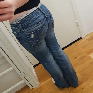 Bootcut jeans strl 28 - Lågmidjade mörkblå bootcut jeans från Fornarina, helt otroliga med jätte fin blekning i storlek 28. Mycket snyggare i verkligheten, midjemått 82cm, innerbenslängd 76cm. Normal i storleken!