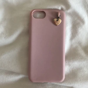 Mobilskal, iPhone 7 - Säljer ett rosa mobilskal för iPhone 7🩷 Kommer ej ihåg vart den är ifrån. Mobilskalet är töjbart och jag antar att det är något form av gummimaterial? På tredje bilden ser ni att hjärtat har rostat lite + smuts i hålet, men det går lätt att få bort. Säljer då jag inte har iPhone 7 längre. Inget är trasigt.