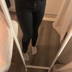 Levi’s 710 super skinny - Snygga svarta skinny jeans med hög midja. Perfekta för en stilren look. De har en klassisk design med dragkedja och knapp framtill.