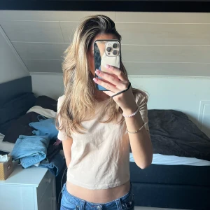 Beige t-shirt från Zara - Säljer en stilren beige t-shirt från Zara. Den har en klassisk rund hals och korta ärmar, perfekt för en avslappnad look. Materialet är mjukt och bekvämt, vilket gör den till ett mångsidigt plagg i garderoben.