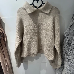 Beige stickad tröja från & Other Stories - Säljer en mysig beige stickad tröja från & Other Stories. Tröjan har en klassisk krage och ett subtilt mönster som ger den en unik touch. 🫶🏼 använt få antal gånger. 