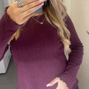 Vinröd ribbad tröja - Säljer denna super söta vinröda ribbade tröjan med en unik detalj nertill! Super fin och super bra skick typ aldrig använd! 