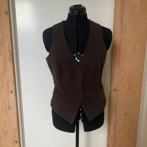 Brun väst - En jätte snygg brunrandig väst med justerbar midja. Köpt secondhand men är i väldigt bra skick. Jag själv har kanske använt den en gång.