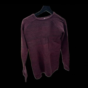 Vinröd stickad tröja - Säljer en vinröd stickad tröja med rund hals och långa ärmar. Perfekt för kyligare dagar och ger en mysig känsla. Den sticks inte.