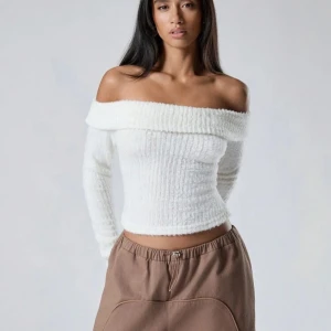 Vit offshoulder stickad tröja - Säljer en stilren vit offshoulder tröja i stickat material. Tröjan är croppad och har långa ärmar, perfekt för en trendig look. Passar utmärkt till både jeans och kjol. Perfekt för kyligare dagar när du vill vara både varm och snygg.